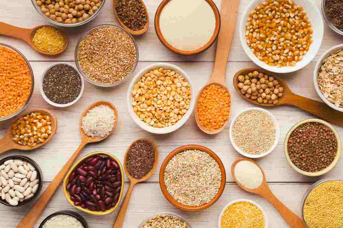 legumi in ciotole e cucchiai di legno