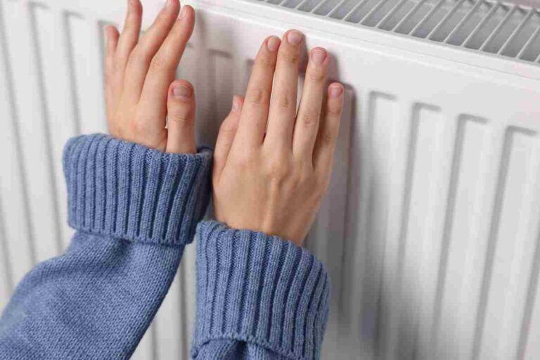 donna riscalda le mani sul termosifone