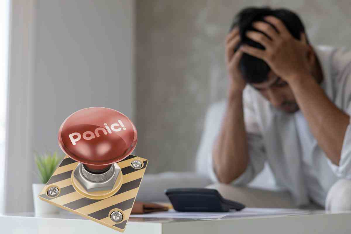 ragazzo con la testa tra le mani e un tasto con la scritta panic