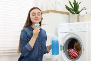 donna che annusa ammorbidente per la lavatrice