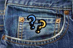 primo piano di una tasca di jeans con punti interrogativi