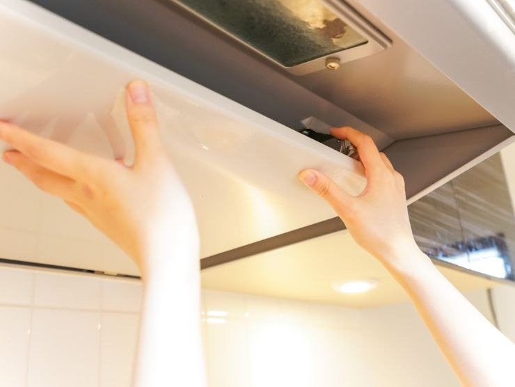 persona che smonta cappa della cucina