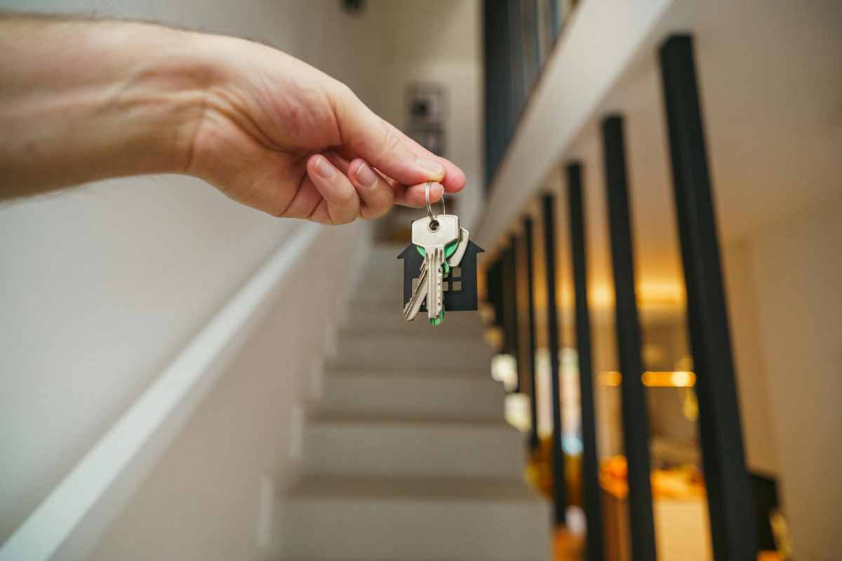 una mano con le chiavi di casa pronta a salire le scale