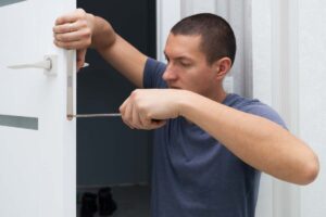uomo cambia la serratura di casa