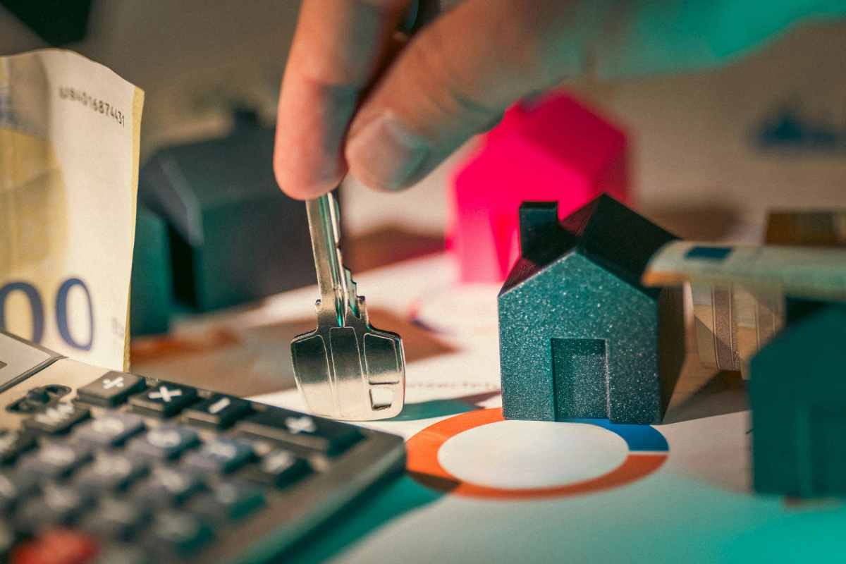 una chiave, chiavi in miniatura e una calcolatrice