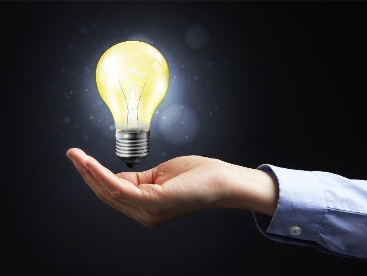 mano che presenta lampadina