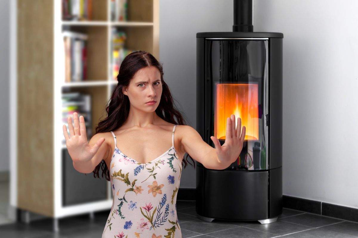 stanza con stufa a pellet e donna che dice no