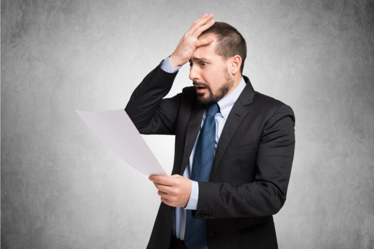 uomo disperato che legge una carta