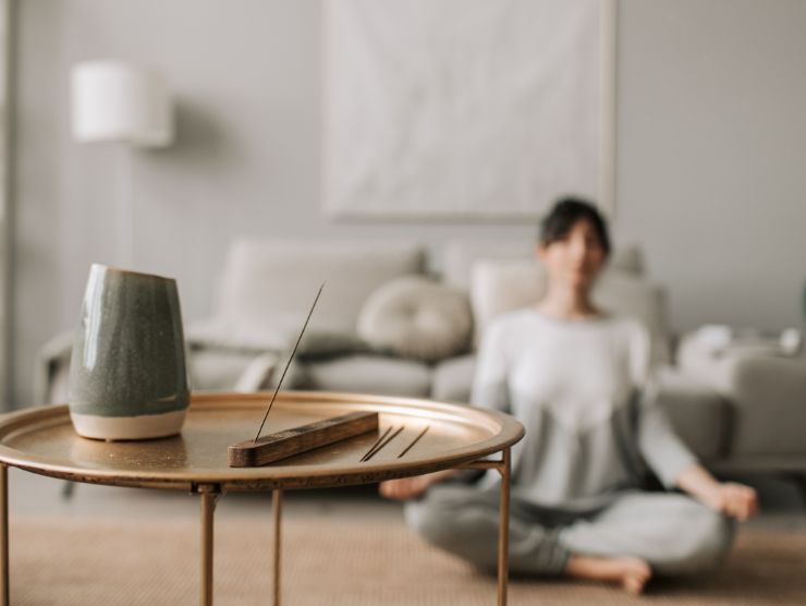 donna che si rilassa sullo sfondo e incenso che profuma in primo piano