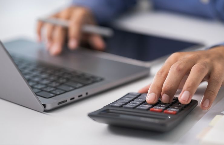 uomo al pc e calcolatrice