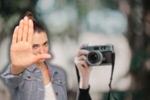 donna che scatta una foto e un'altra che fa stop con le mani