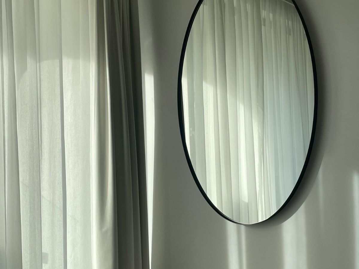 specchio ovale vicino a una finestra