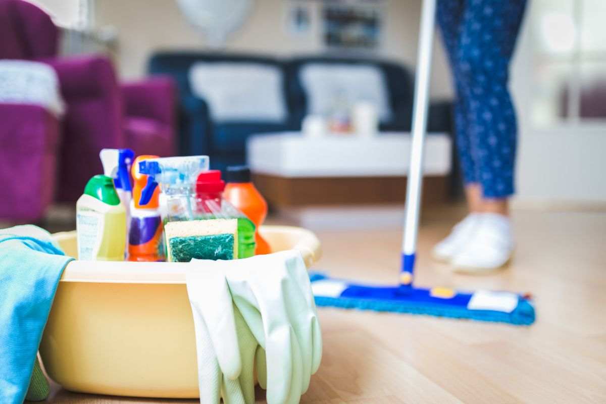 kit di pulizie e donna che pulisce