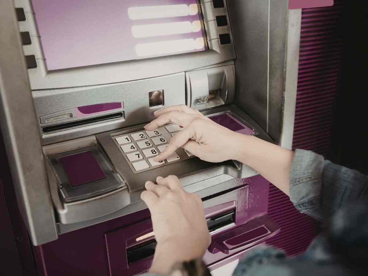 donna digita codice presso un bancomat