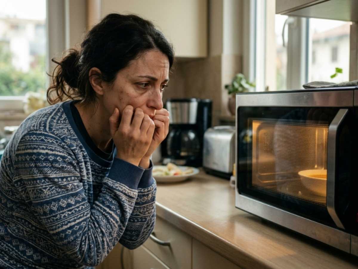 donna preoccupata guarda microonde