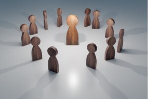 rappresentazione di omini in legno in cerchio e un leader al centro