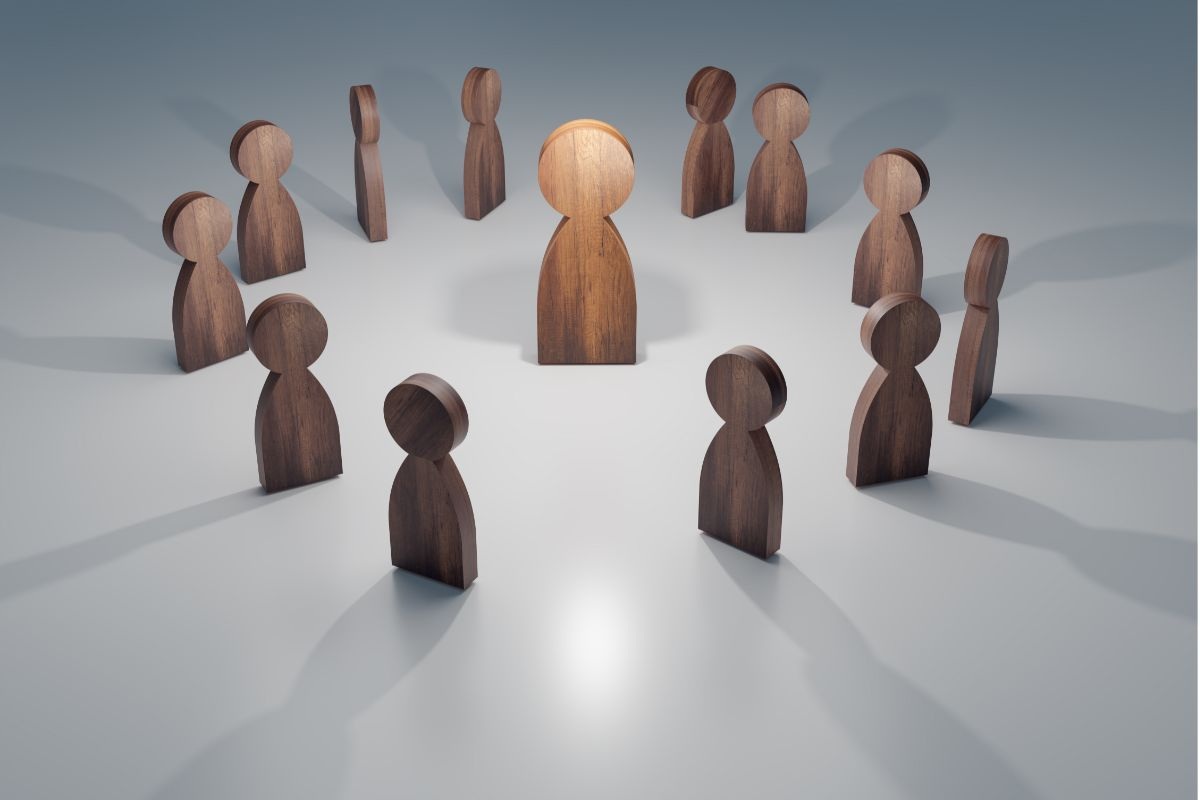 rappresentazione di omini in legno in cerchio e un leader al centro