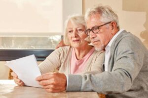 coppia di anziani con foglio in mano