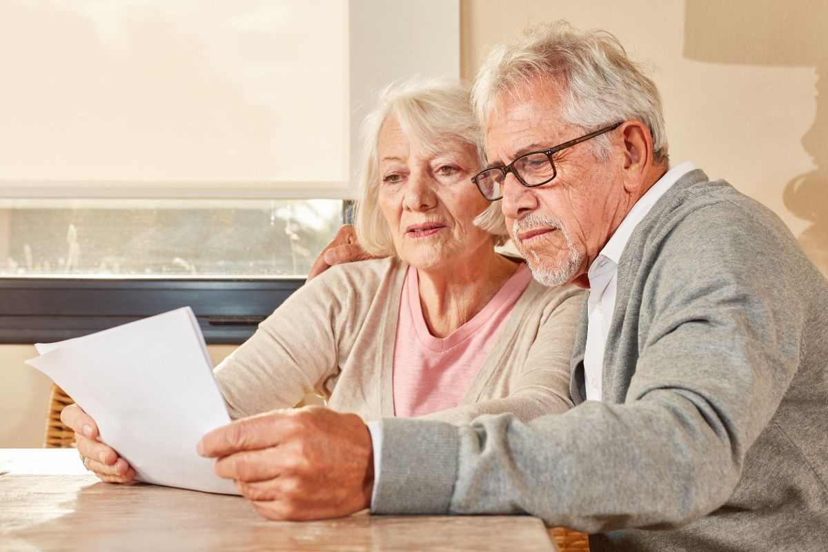 coppia di anziani con foglio in mano