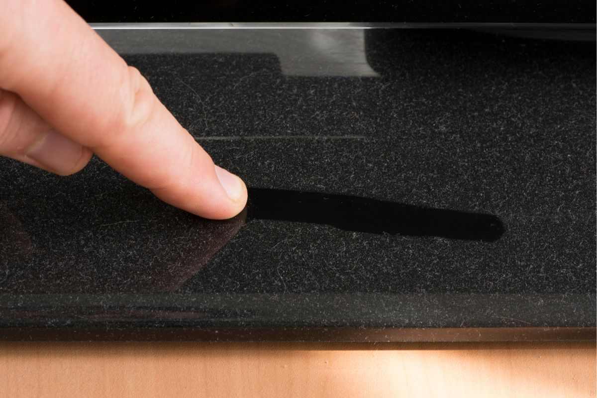 segno di un dito lasciato su uno strato di polvere