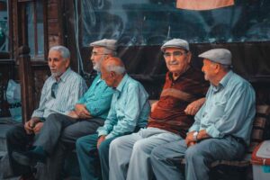 uomini anziani seduti per strada