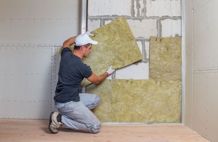 operaio che installa il cappotto termico