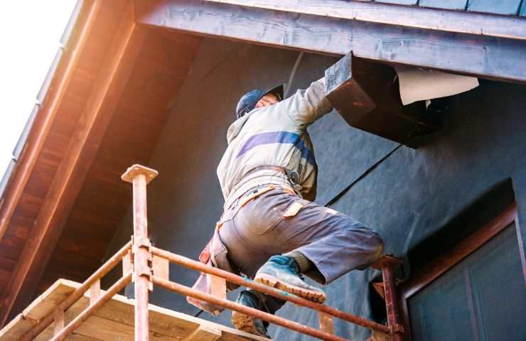 operaio che installa cappotto termico all'esterno di un edificio