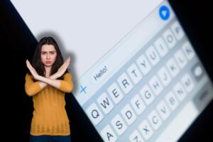 messaggio su smartphone e donna che fa stop con le mani