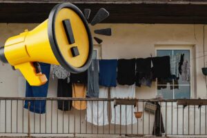panni stesi sul balcone e megafono giallo con bordi neri