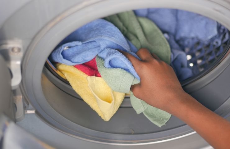 donna con mani in lavatrice