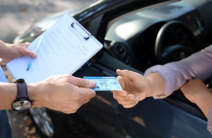 uomo che consegna patente