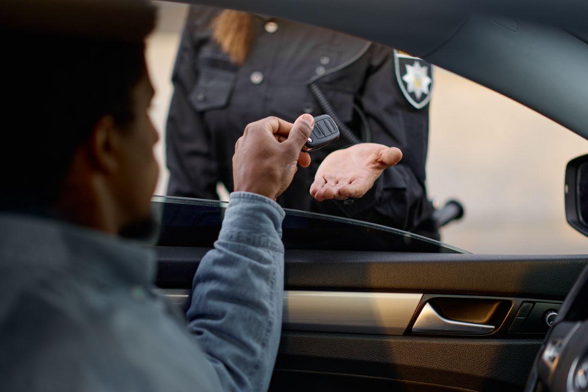 poliziotto e guidatore che consegna chiavi dell'auto